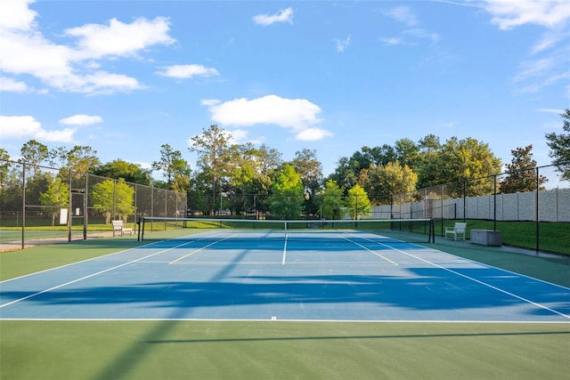 view of tennis court featuring fence and community basketball court