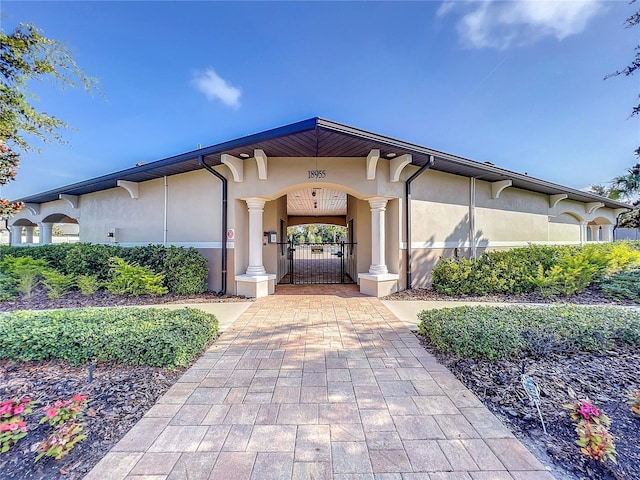 mediterranean / spanish house with stucco siding and a gate