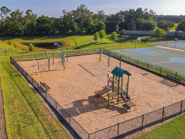 surrounding community featuring community basketball court and a water view