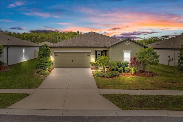 ranch-style house with an attached garage, driveway, a yard, and stucco siding