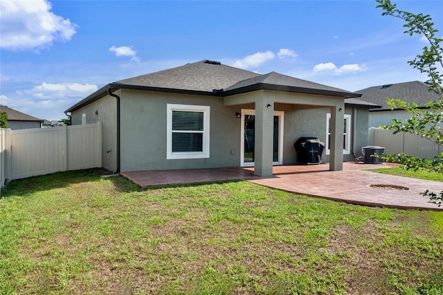 rear view of house with stucco siding, a patio area, central air condition unit, and roof with shingles