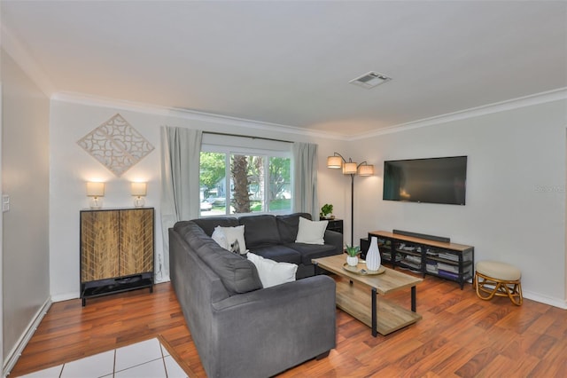 living room featuring baseboards, visible vents, crown molding, and wood finished floors