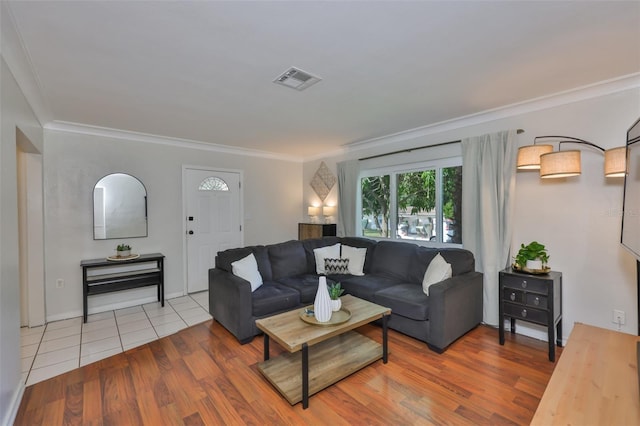 living room with visible vents, wood finished floors, and ornamental molding