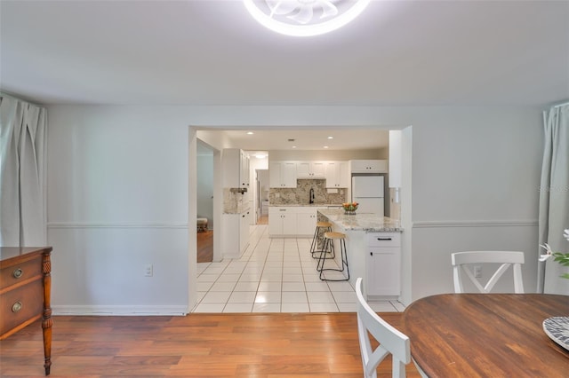 dining area featuring light wood-style floors, baseboards, and recessed lighting