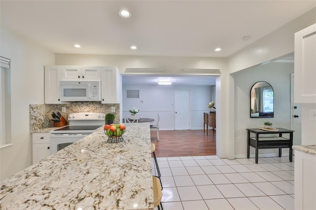 kitchen featuring white cabinetry, recessed lighting, white appliances, and tasteful backsplash