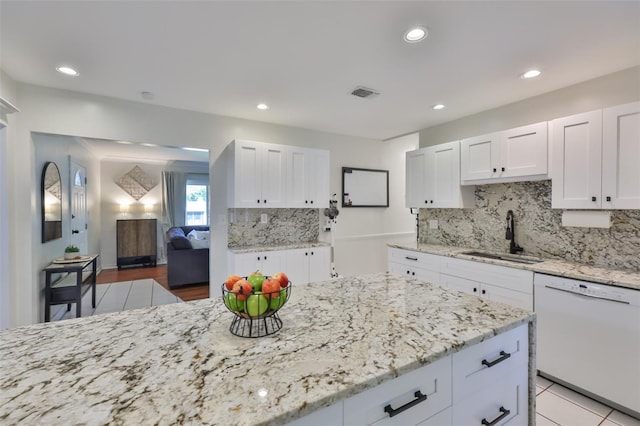 kitchen with dishwasher, white cabinetry, visible vents, and a sink