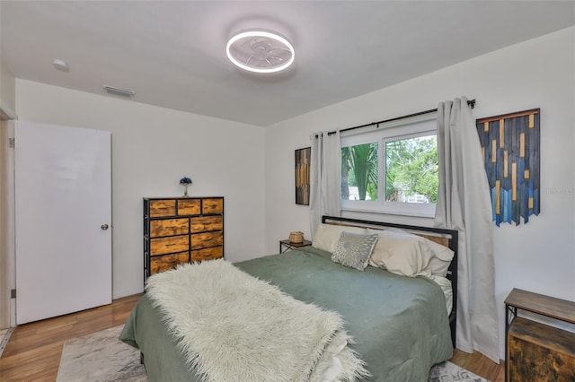 bedroom featuring visible vents and wood finished floors