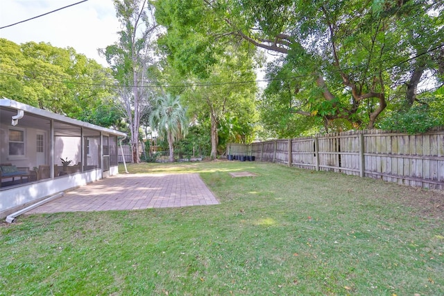 view of yard with a sunroom, a patio area, and a fenced backyard