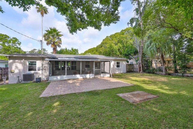 back of house featuring a lawn, cooling unit, a patio area, a sunroom, and a fenced backyard