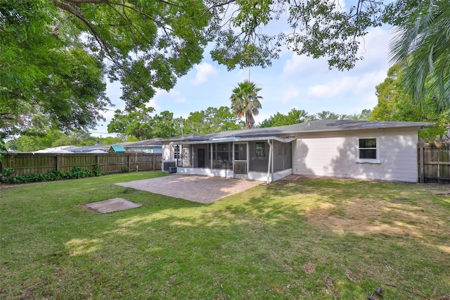 rear view of house with a sunroom, a patio, a fenced backyard, and a yard