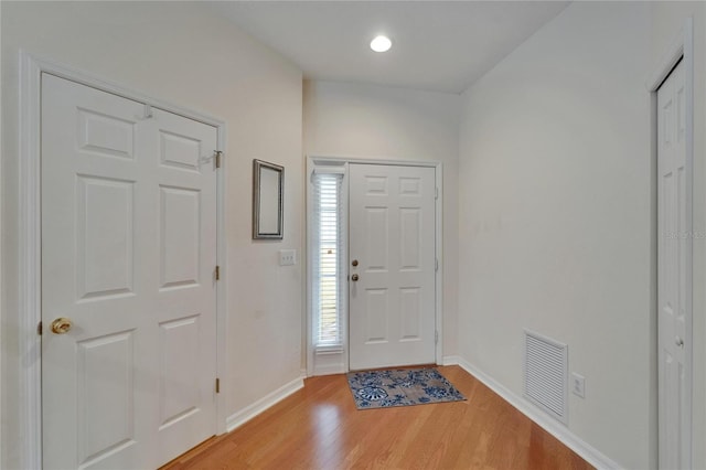 foyer featuring light wood finished floors, visible vents, and baseboards