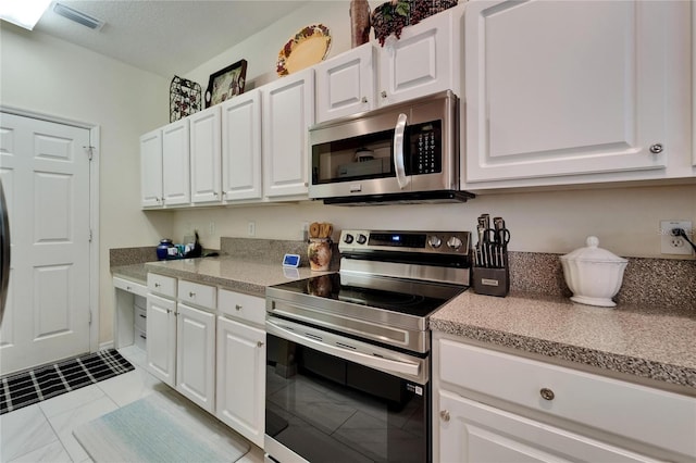 kitchen with white cabinets, light countertops, stainless steel appliances, and visible vents