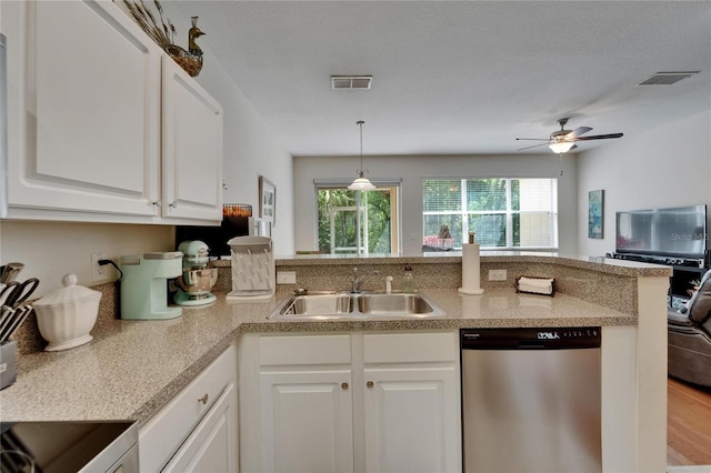 kitchen featuring white cabinets, stainless steel dishwasher, visible vents, and a sink