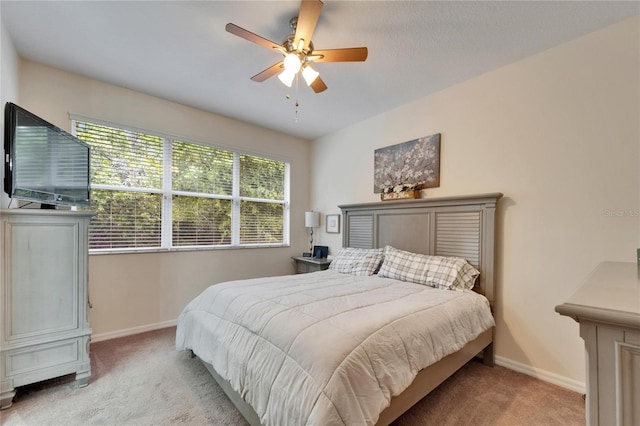 bedroom featuring baseboards, light carpet, and a ceiling fan