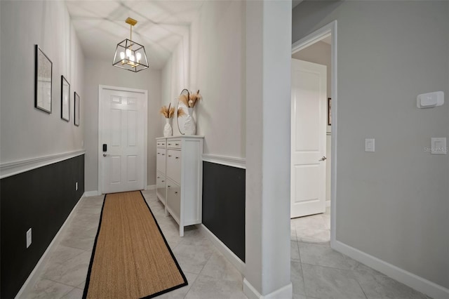 entrance foyer featuring a chandelier and baseboards