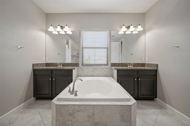 bathroom featuring a bath, two vanities, and baseboards