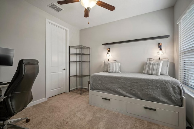 bedroom with light colored carpet, a desk, baseboards, and a ceiling fan