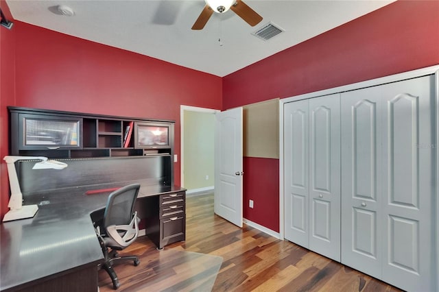 office space with baseboards, a ceiling fan, visible vents, and wood finished floors