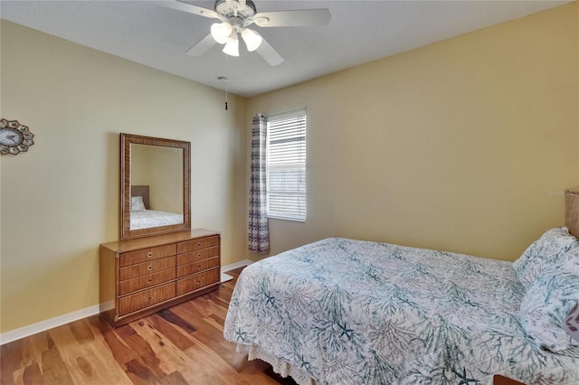 bedroom with baseboards, a ceiling fan, and wood finished floors