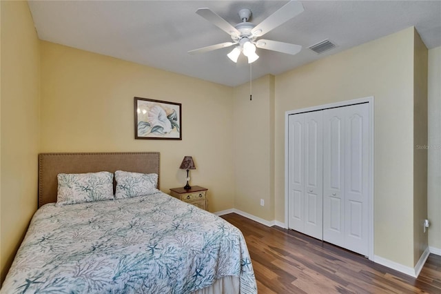 bedroom with baseboards, a closet, visible vents, and wood finished floors