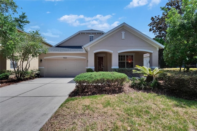 view of front facade featuring an attached garage, stucco siding, and driveway