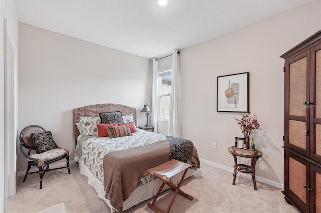 bedroom featuring light colored carpet and baseboards