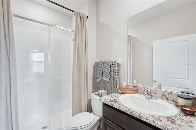 full bathroom featuring a shower stall, toilet, and vanity