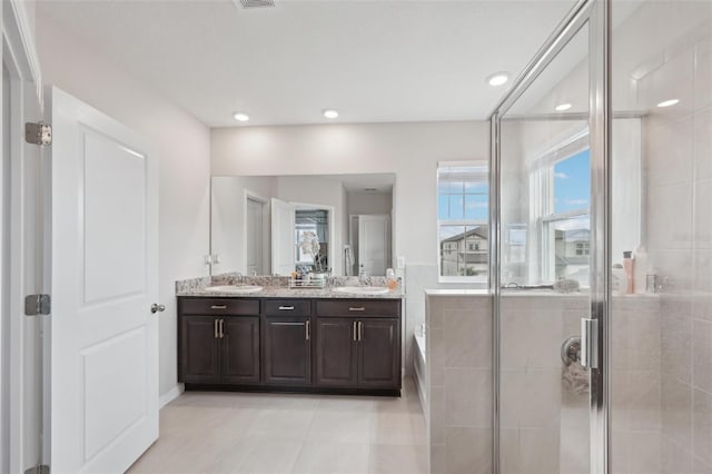 bathroom featuring a shower stall, double vanity, a garden tub, tile patterned flooring, and recessed lighting