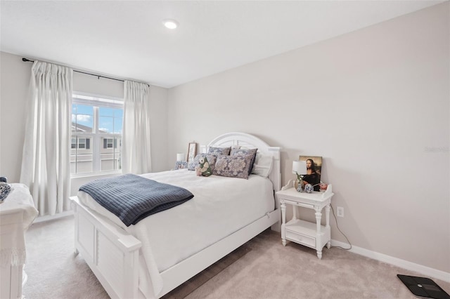 bedroom with light colored carpet and baseboards