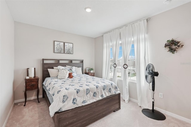 bedroom featuring light colored carpet and baseboards