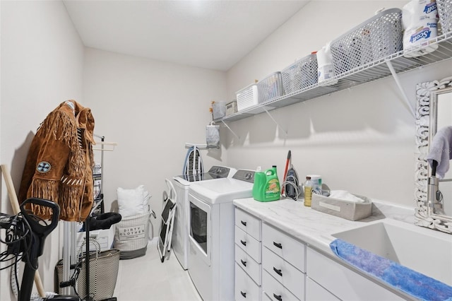 washroom with washing machine and clothes dryer, light tile patterned floors, and cabinet space