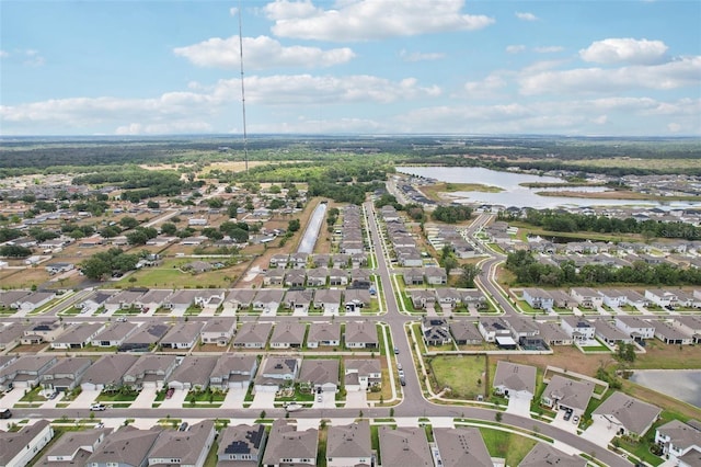 aerial view of property and surrounding area with a nearby body of water and nearby suburban area
