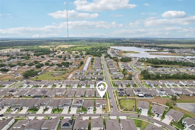 aerial view of property and surrounding area featuring a nearby body of water and nearby suburban area