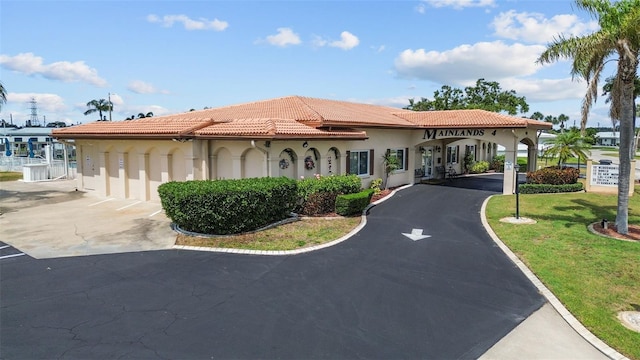 9743 36th Way N Unit 4, Pinellas Park, FL 33782 - mediterranean / spanish-style house featuring stucco siding, a tiled roof, asphalt driveway, and a front lawn
