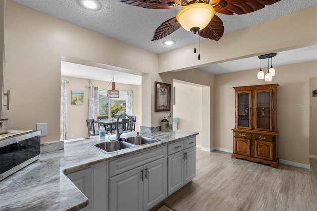 9743 36th Way N Unit 4, Pinellas Park, FL 33782 - kitchen featuring a sink, stainless steel microwave, a ceiling fan, light wood finished floors, and hanging light fixtures