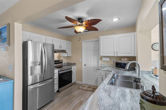 9743 36th Way N Unit 4, Pinellas Park, FL 33782 - kitchen with stainless steel appliances, a sink, under cabinet range hood, light wood-style flooring, and white cabinets