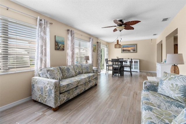 9743 36th Way N Unit 4, Pinellas Park, FL 33782 - living room with ceiling fan, light wood-style flooring, a textured ceiling, and baseboards