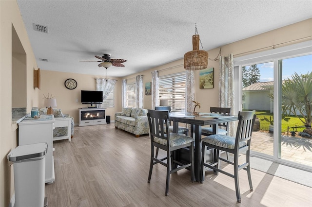9743 36th Way N Unit 4, Pinellas Park, FL 33782 - dining space featuring healthy amount of natural light, a textured ceiling, light wood-style flooring, and ceiling fan