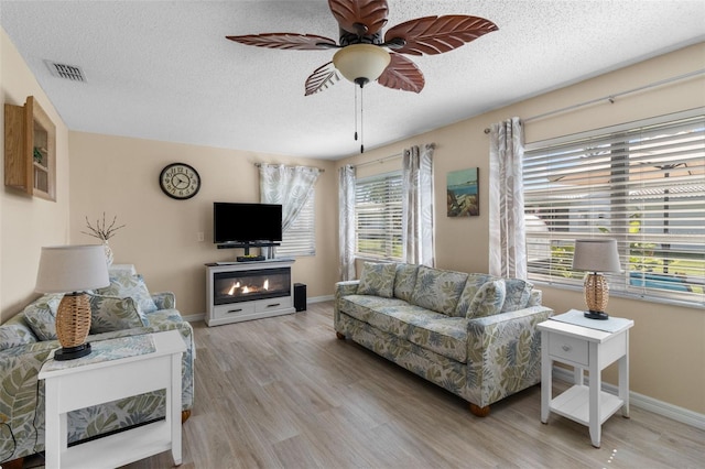 9743 36th Way N Unit 4, Pinellas Park, FL 33782 - living area featuring a ceiling fan, light wood-style floors, a textured ceiling, and baseboards