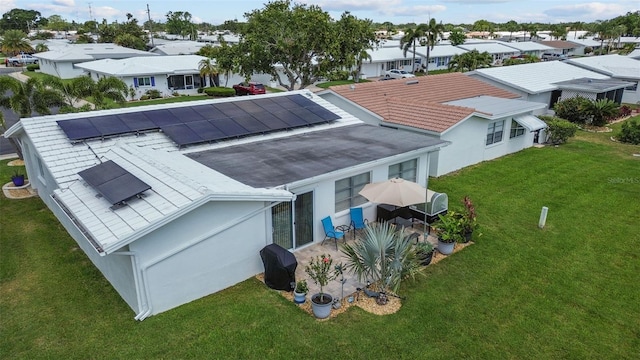 9743 36th Way N Unit 4, Pinellas Park, FL 33782 - back of house with roof mounted solar panels, a residential view, and a yard