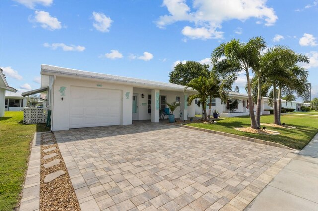 9743 36th Way N Unit 4, Pinellas Park, FL 33782 - view of front facade featuring a garage, decorative driveway, a front lawn, and stucco siding