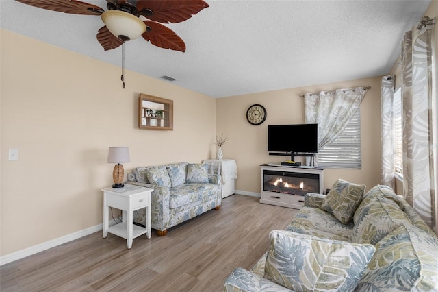 9743 36th Way N Unit 4, Pinellas Park, FL 33782 - living room with wood finished floors, a textured ceiling, and a ceiling fan