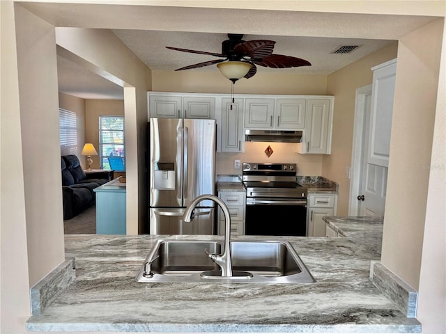 9743 36th Way N Unit 4, Pinellas Park, FL 33782 - kitchen featuring appliances with stainless steel finishes, under cabinet range hood, a ceiling fan, white cabinetry, and light countertops