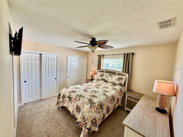 9743 36th Way N Unit 4, Pinellas Park, FL 33782 - bedroom with two closets, a textured ceiling, dark colored carpet, and ceiling fan