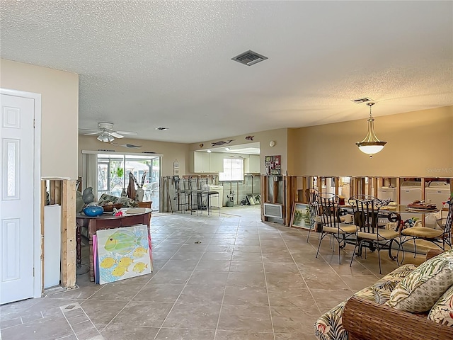 1011 SE 4th Ave, Crystal River, FL 34429 - living room featuring ceiling fan, a textured ceiling, light tile patterned floors, and visible vents