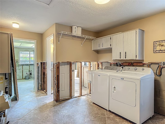 1011 SE 4th Ave, Crystal River, FL 34429 - clothes washing area featuring a textured ceiling, separate washer and dryer, and cabinet space