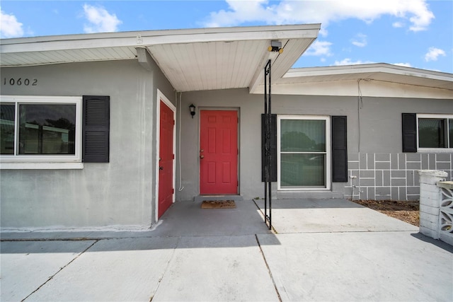 view of exterior entry featuring stucco siding