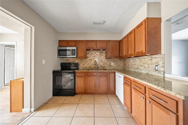 kitchen with white dishwasher, a sink, stainless steel microwave, black range with electric stovetop, and brown cabinets