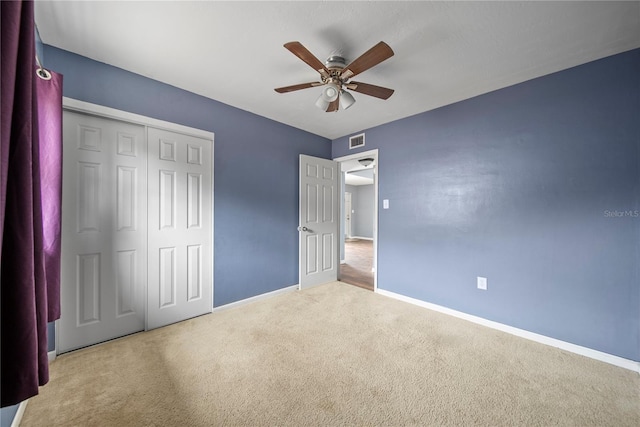 unfurnished bedroom featuring baseboards, a closet, visible vents, and carpet floors