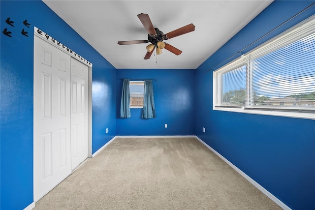 unfurnished bedroom featuring carpet flooring, a closet, baseboards, and multiple windows